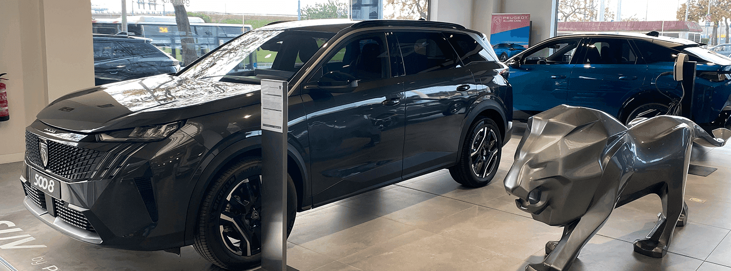 Imagen del concesionario Peugeot en versión escritorio con exposición de vehículos y atención al cliente